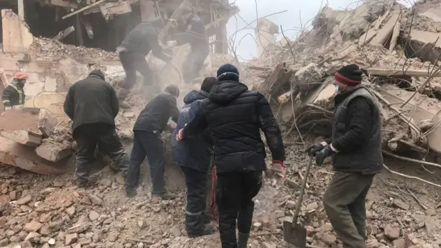 Rescuers work through wreckage after apparent artillery strike