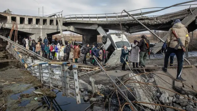 Residents cross the destroyed bridge as they flee from the frontline town of Irpin, Kyiv (Kiev) region, Ukraine, 09 March 2022.