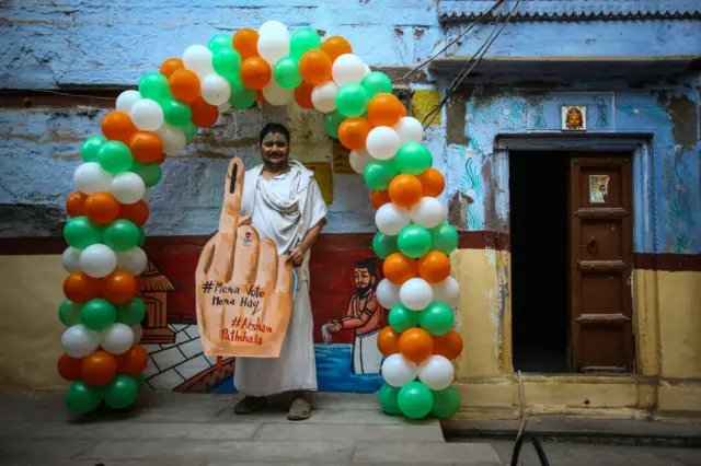 A resident poses for a photograph with props after casting his vote during the seventh phase of state elections on March 07, 2022 in Varanasi, India.