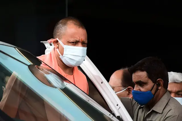 Chief Minister of India's Uttar Pradesh state Yogi Adityanath (C) arrives at the SRN Hospital to inspect the special Covid-19 coronavirus ward in Allahabad on April 9, 2021.