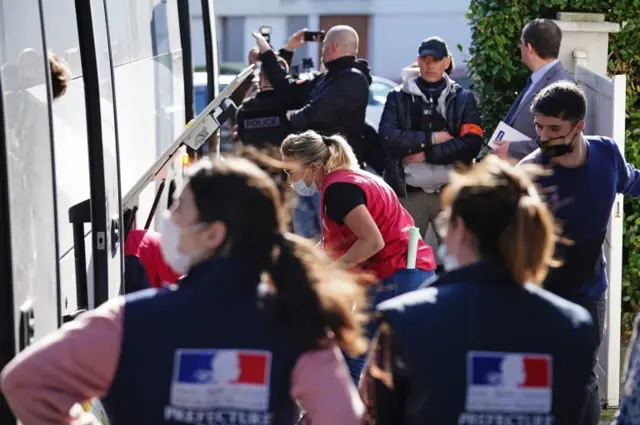 French police block the view of Ukrainian refugees loading their belongings onto a bus before it departs from the Centre Europeen de Sejours youth hostel in Calais