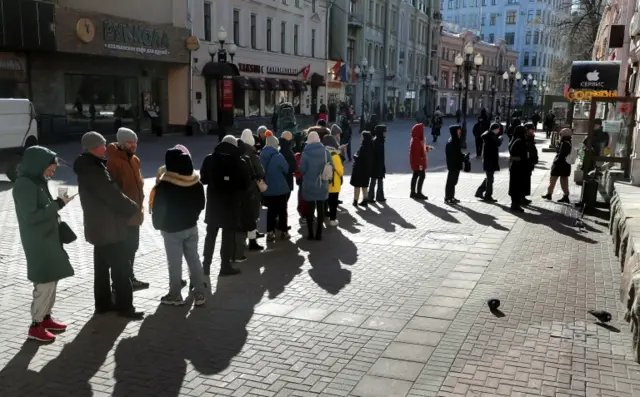 People wait in line to withdraw cash from a ATM of Tinkoff Bank downtown Moscow, Russia 09 March 2022.