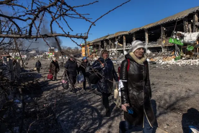 Residents coming from Bucha town, which is currently controlled by the Russian military, walk with luggage towards the Ukrainian checkpoint, at the frontline in Irpin town, Kyiv (Kiev) region, Ukraine,