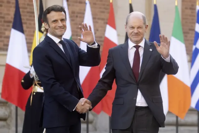 French President Emmanuel Macron (L) welcomes German Chancellor Olaf Scholz ahead of an informal meeting of EU heads