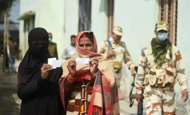 Two women holding voting slips in UP on 27 February