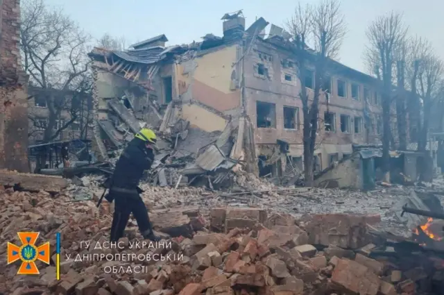 A rescuer works among remains of buildings damaged by an air strike, as Russia's attack on Ukraine continues, in Dnipro, Ukraine, in this handout picture released on 11 March 2022