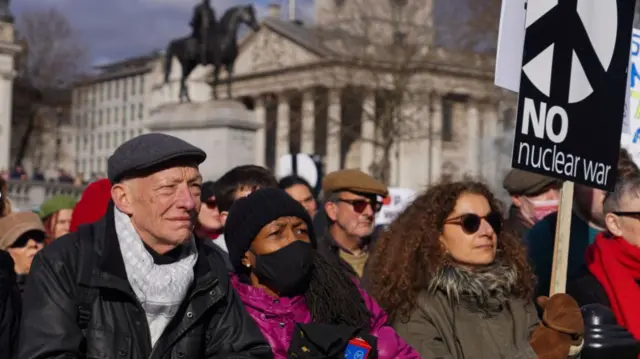 A protester in London holds a sign reading 'no nuclear war'