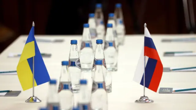 Russian and Ukrainian flags are seen on a table before the talks between officials of the two countries in the Gomel region, Belarus