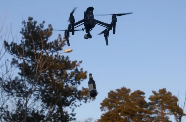 The bottle stays upright after being released by the drone