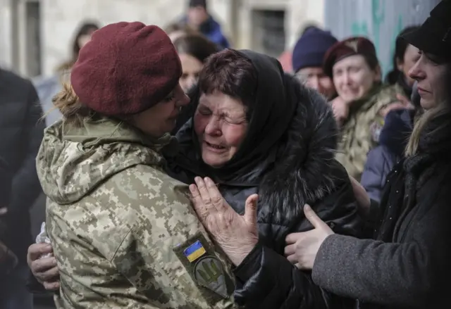 A Ukrainian woman cries during a funeral ceremony of three Ukrainian soldiers killed in fighting with Russian forces