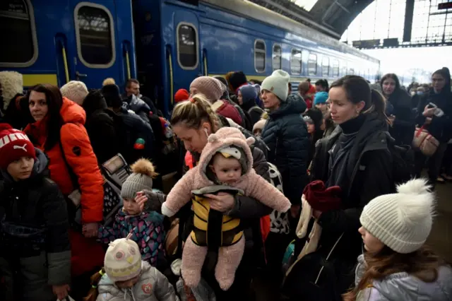 People fleeing Russia's invasion of Ukraine gather at the train station in Lviv