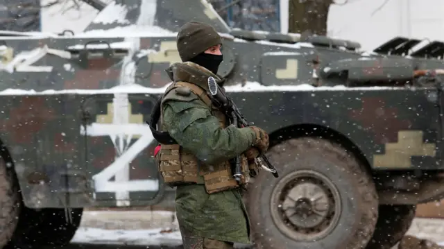 A service member of pro-Russian troops stands on a street of the separatist-controlled village of Anadol during Ukraine-Russia conflict in the Donetsk region, Ukraine