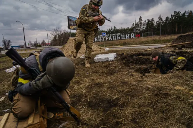 Ukrainian troops take cover from Russian artillery near Irpin