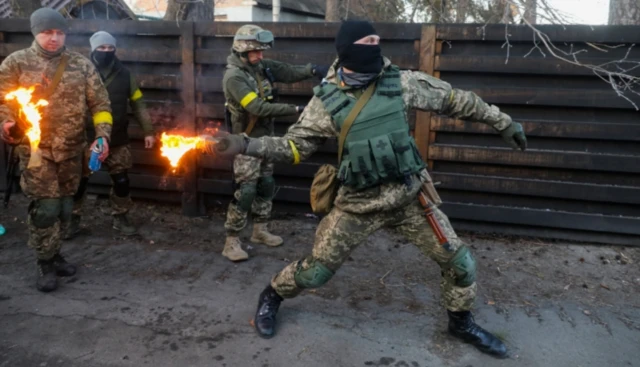 A Ukrainian soldier throws a Molotov cocktail as part of a training exercise