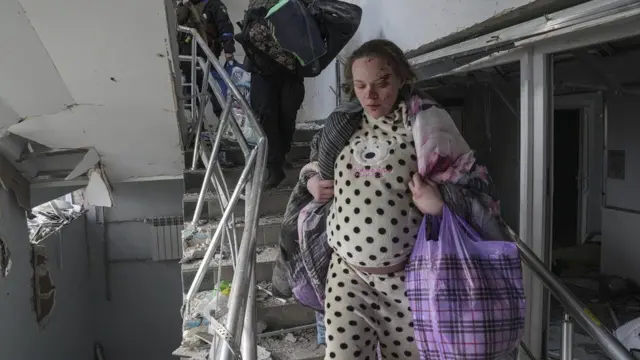 Pregnant woman leaving bombed hospital