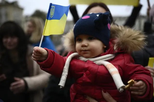 A child in Turin holds a Ukrainian flag