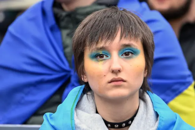 A protester has her face made up with Ukrainian national colours during a support demonstration in Paris