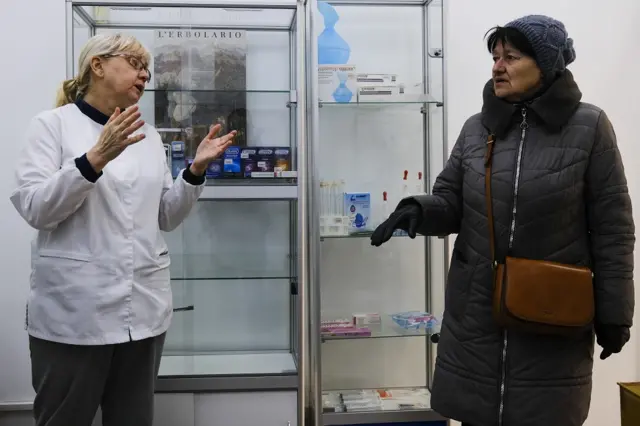 A pharmacy worker tells a woman she doesn't have the medicines the woman is looking for