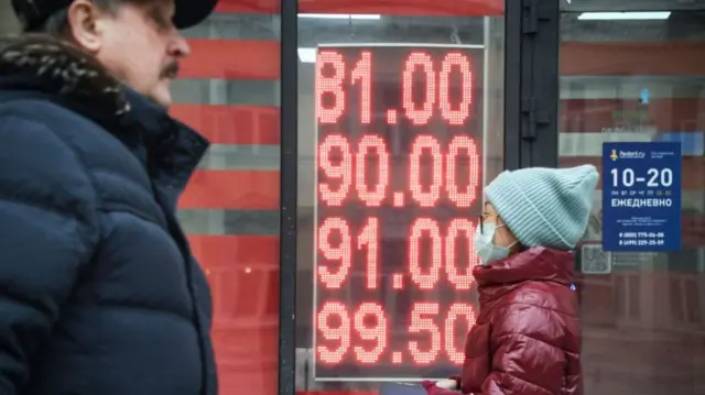 People walk by a currency exchange in Moscow