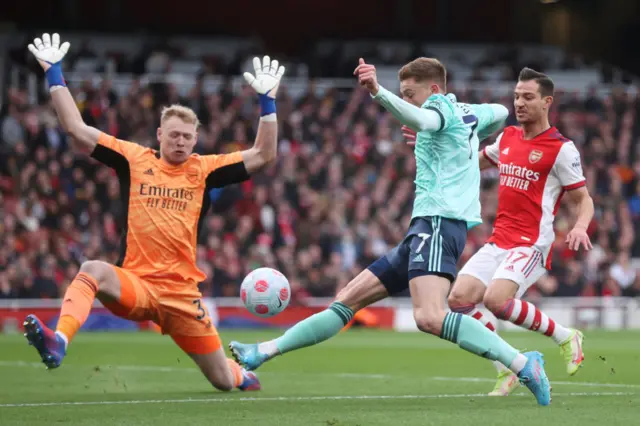 Aaron Ramsdale of Arsenal makes a save from Harvey Barnes