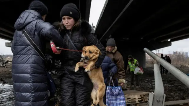 A woman carries her dog during an evacuation from the town of Irpin outside Kyiv