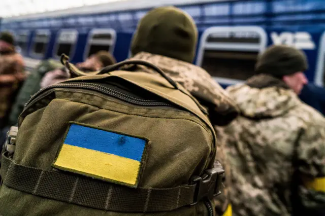 Ukrainian soldiers in Lviv prepare to travel to the frontline