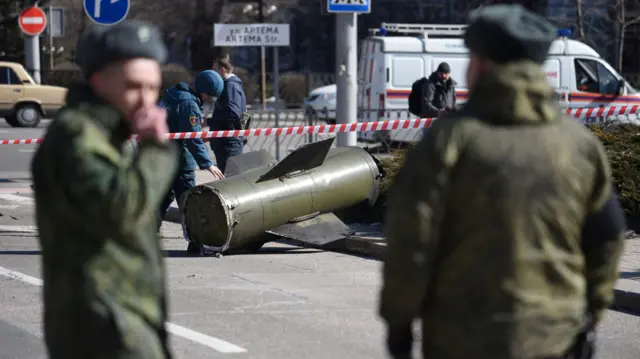 A member of the Emergencies Ministry of the separatist area of Donetsk inspects the remains of a missile that landed in the street in the separatist-controlled city of Donetsk, Ukraine