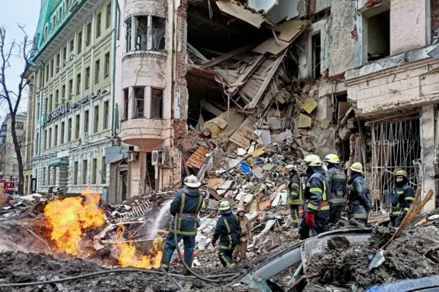 Emergency services at the scene of an air strike in Kharkiv