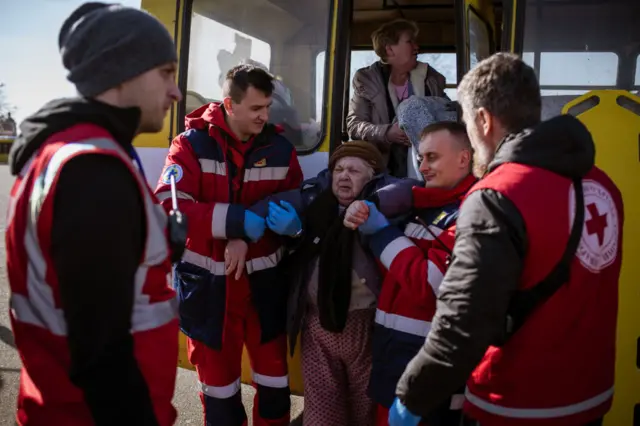 Civilian evacuee and emergency personnel near Kyiv