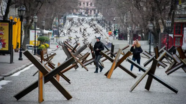 Pedestrians walk among anti-tank barriers in Odesa on Monday