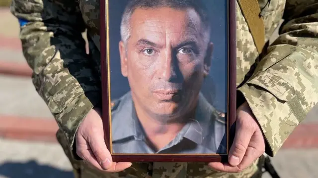 Soldier holds photo of Colonel Valeriy Gudz