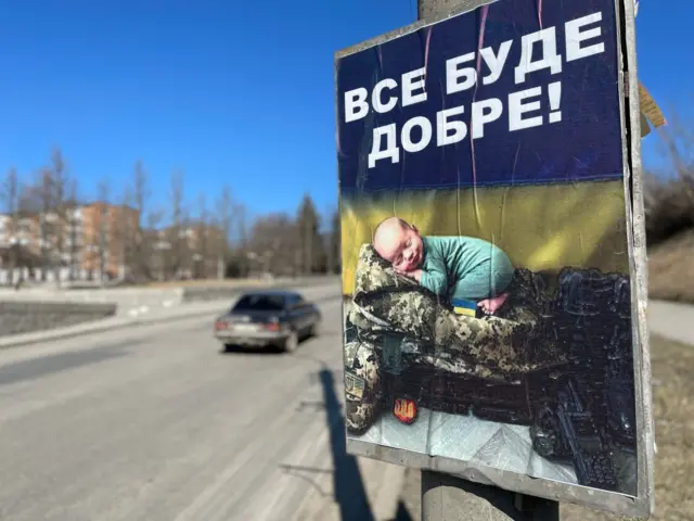 A sign of a baby curled up on a Ukrainian military uniform