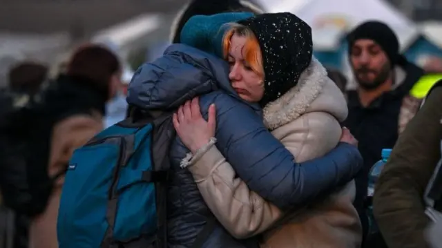 Refugees hug at the Poland-Ukraine border