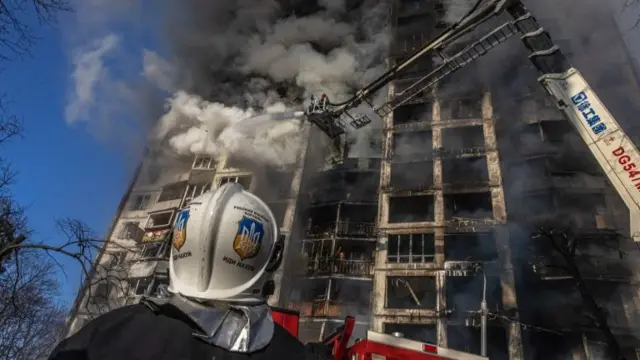 Firefighters put out a fire in a residential building which was hit by strikes, in Kyiv, Ukraine, on 15 March 2022