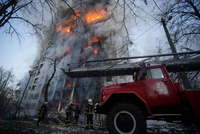 Firefighting crews outside a tall residential building in Kyiv