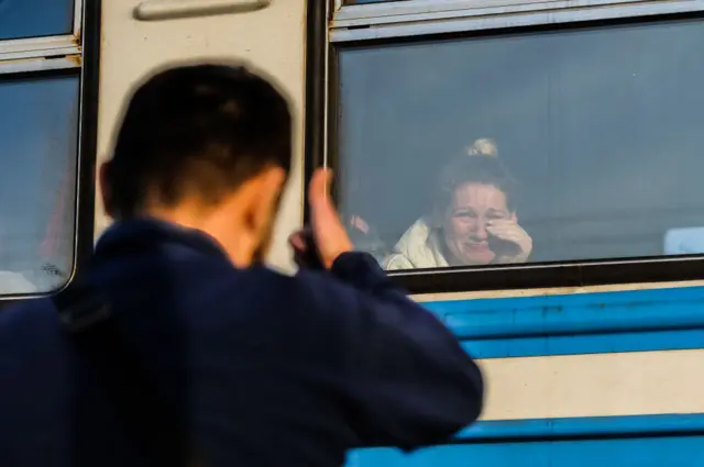 A woman cries on a train to Poland leaving from Lviv train station