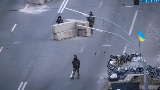 Ukrainian troops guard a checkpoint outside Kyiv