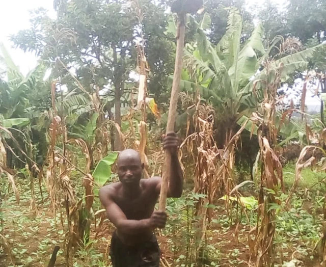 Adrien Nimpagaritse with a hoe on his farm