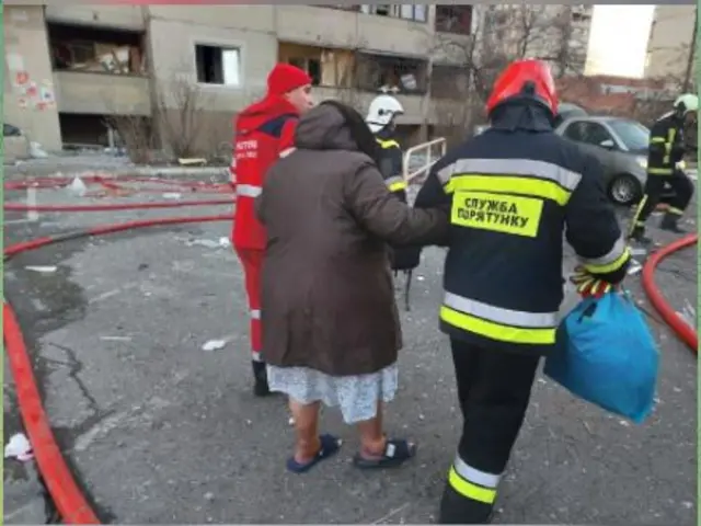 Firefighters and rescue personnel evacuating residents from the tower block