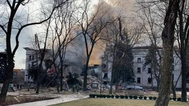 Smoke billowing from the theatre with a completely collapsed facade