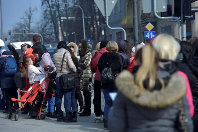 Refugees who fled Russia"s invasion of Ukraine wait in a queue to obtain Polish national identification number