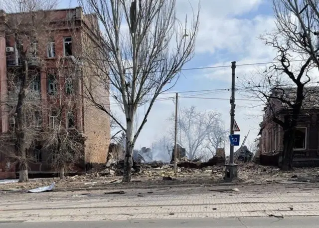 A gap between buildings where a home once stood in Mariupol