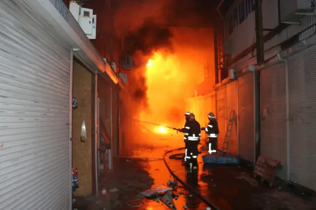 Firefighters hosing a fire in Kharkiv