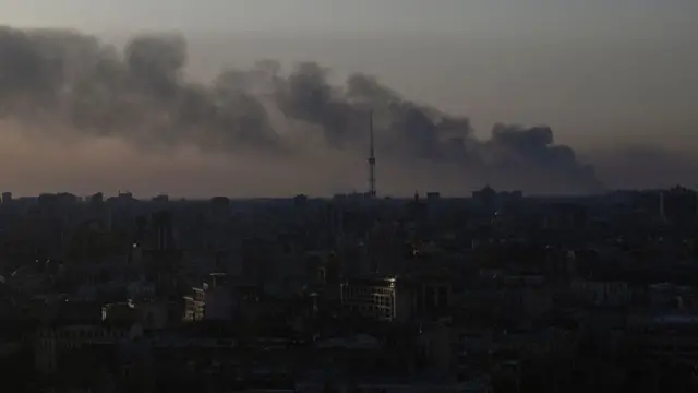 Kyiv skyline with smoke rising