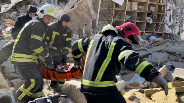 Rescue workers carry a man on a stretcher at the Ukrainian military barracks on the northern edge of Mykolaiv