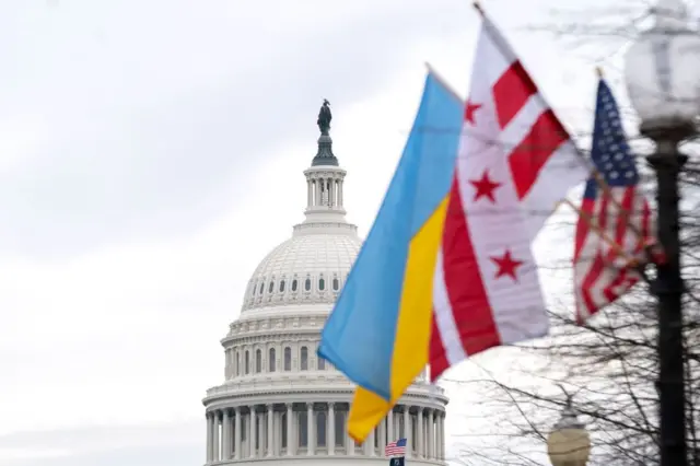 The Ukrainian flag flies with the US and Washington DC flags on Tuesday outside the US Capitol