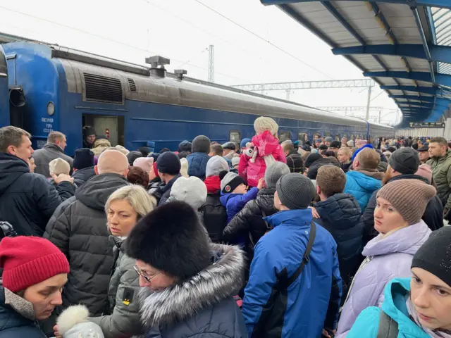 Crowds gather on a station platform as train arrives in Dnipro