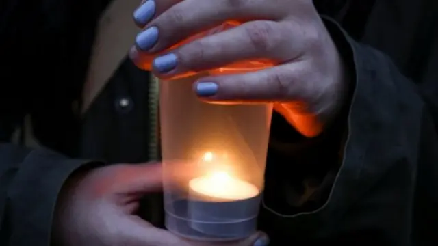 A demonstrator holds a candle during a protest in solidarity with Ukraine, after Russia launched a massive military operation against the country.