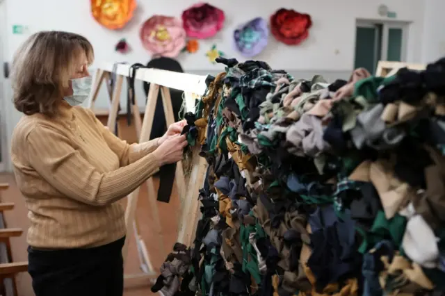 Volunteer making camouflage nets