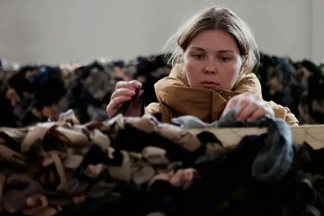 Volunteer making camouflage nets